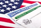 Une carte de résident permanent des États-Unis et une carte de Sécurité sociale posées en éventail sur un drapeau américain