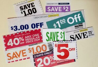 Coupons de réduction découpés dans des prospectus américains et étalés sur une table : « Save $1.00 », « Save $2 », « $3.00 off », 40 % de remise sur un article au prix normal, « $5 off »