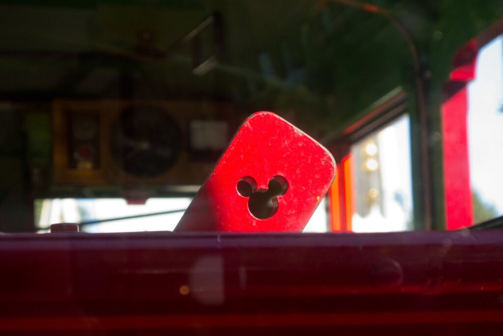 Une poignée métallique découpée en forme de tête de Mickey, dans un wagon du train de Disneyland