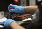 Mains gantées d'un agent des douanes américaines qui tamponne un passeport à son guichet