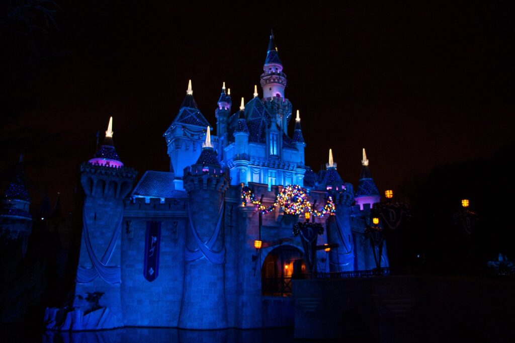Le château de la Belle au bois dormant de Disneyland éclairé en bleu, de nuit, avec ses décorations de Noël