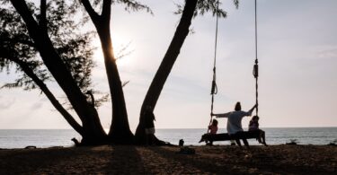Une famille au bord de la mer au coucher du soleil