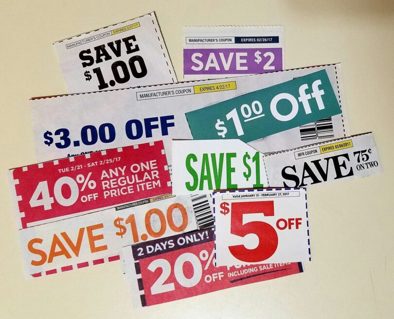 Coupons de réduction découpés dans des prospectus américains et étalés sur une table : « Save $1.00 », « Save $2 », « $3.00 off », 40 % de remise sur un article au prix normal, « $5 off »