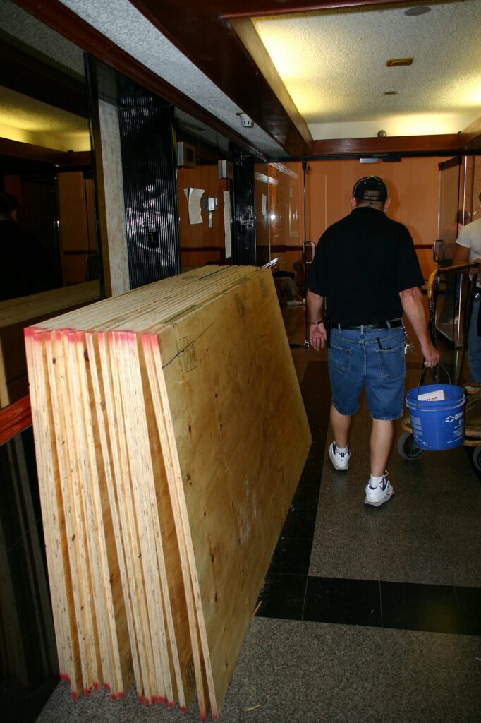 Dans le hall, des panneaux de contreplaqué qui vont servir à protéger les appartements dont les fenêtres ont été brisées (après l'ouragan Wilma, octobre 2005)
