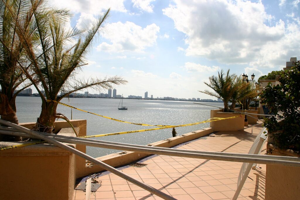 Face à la baie de Biscayne, la rambarde de sécurité arrachée par le vent et les palmiers ébouriffés (après l'ouragan Wilma, octobre 2005)