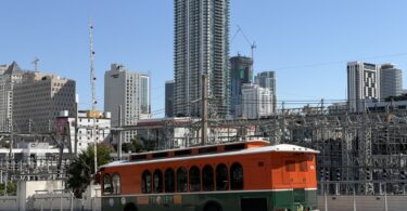 Trolley orange et vert de la ville de Miami à l'arrêt devant les tours de Downtown