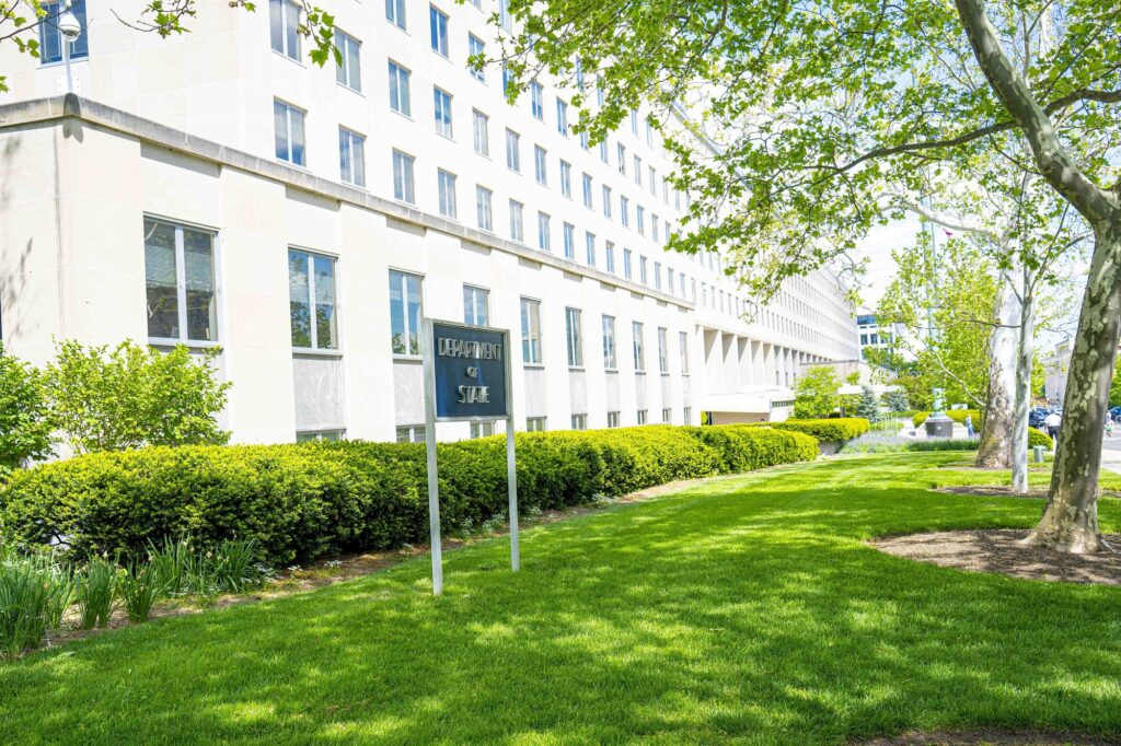 Façade du Harry S. Truman Building, siège du Département d'État, avec le panneau Department of State sur une pelouse