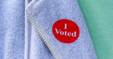 Un électeur porte l'autocollant « I Voted » remis à la sortie du bureau de vote, le jour de l'élection