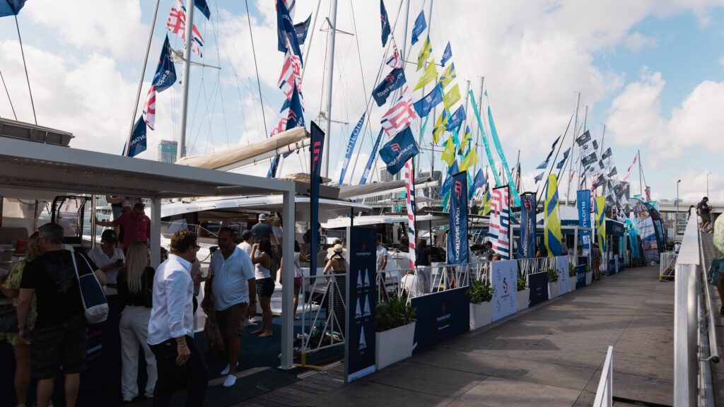Visiteurs sur les pontons de Sailor's Cove, devant des catamarans pavoisés