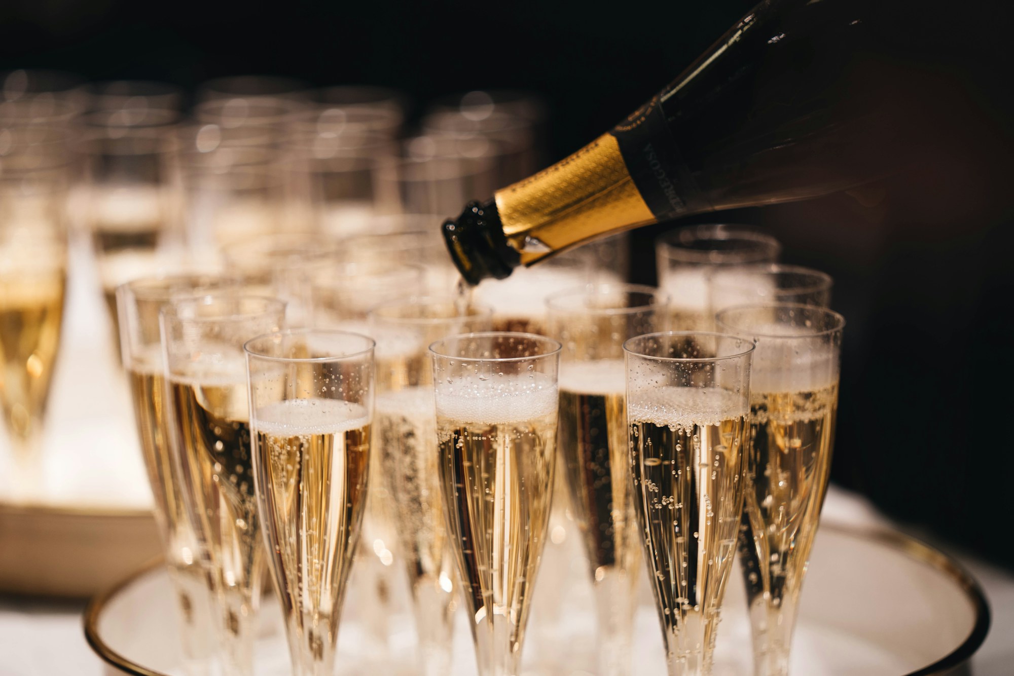 Champagne versé dans une rangée de flûtes