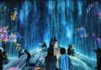 Visiteurs dans une salle d'art numérique immersif, projections du sol aux murs