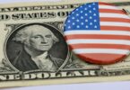 Billet de un dollar à l'effigie de George Washington, sur lequel est posé un badge rond au drapeau américain