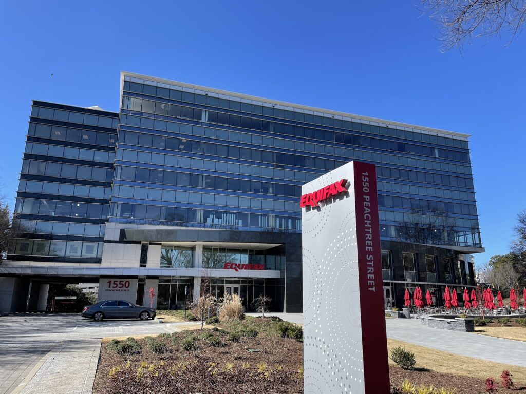 Immeuble de verre du siège d'Equifax, 1550 Peachtree Street à Atlanta, avec son totem au logo rouge de l'entreprise devant l'entrée