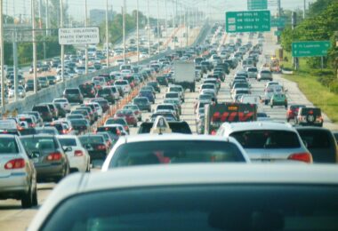 Embouteillage sur l'autoroute I-95 en direction du nord à Miami : des centaines de voitures sur plusieurs voies, sous des panneaux verts de sortie