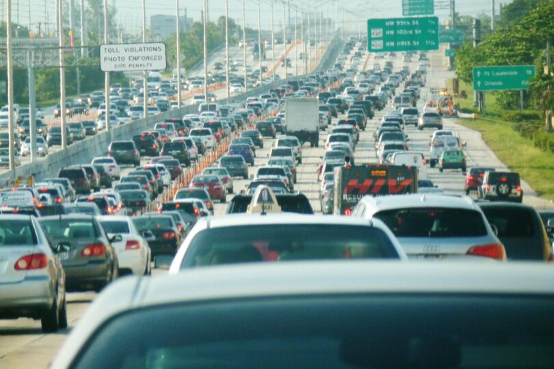 Embouteillage sur l'autoroute I-95 en direction du nord à Miami : des centaines de voitures sur plusieurs voies, sous des panneaux verts de sortie