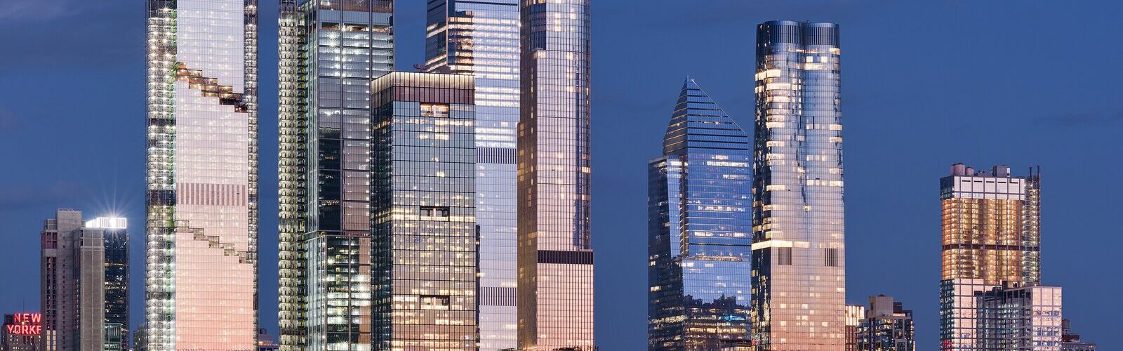 Les gratte-ciel de Hudson Yards et de Midtown Manhattan illuminés au crépuscule, vus depuis l’Hudson